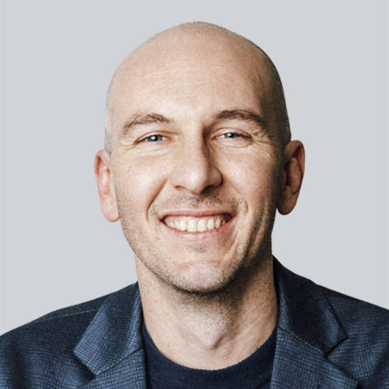 Ein Mann lächelt in die Kamera.